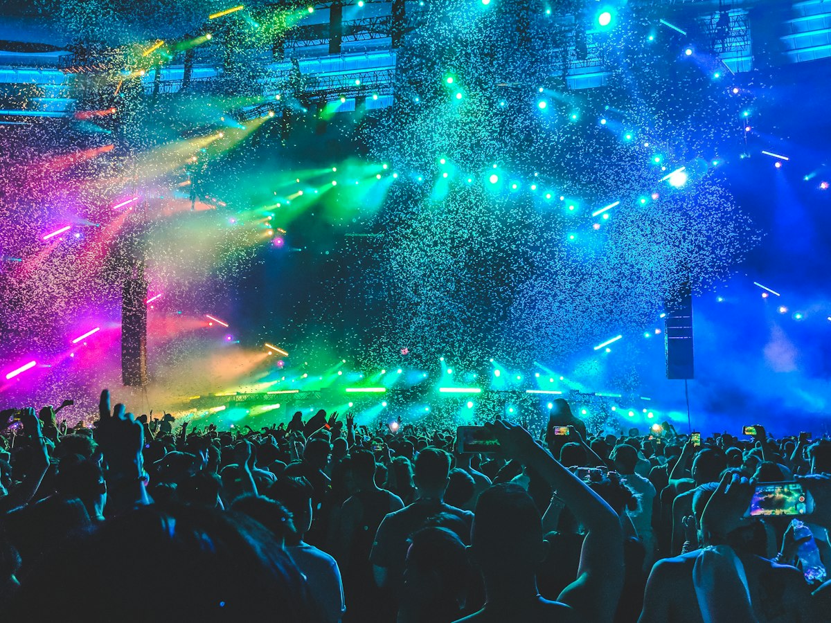 Concert crowd under colorful stage lights and confetti