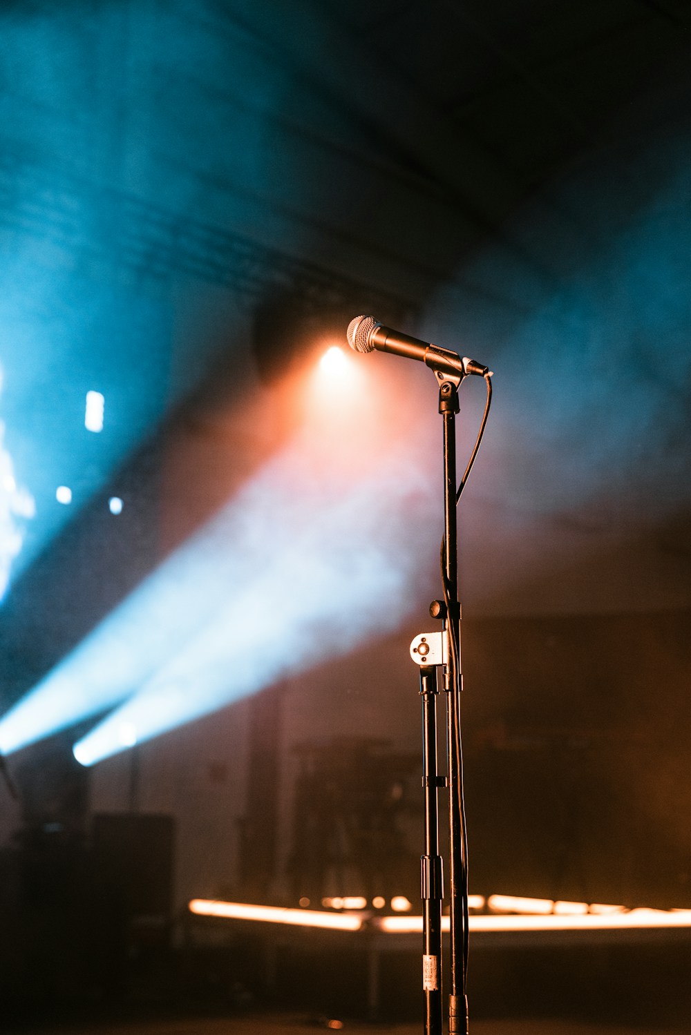 Microphone on stage under blue and orange lights